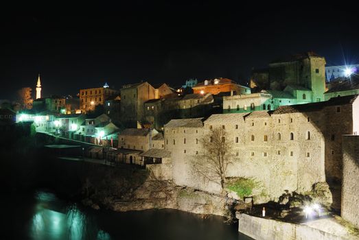 Famous touristic place Mostar viewed from The Old Bridge by night. 