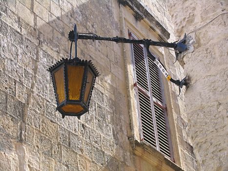 Old street lantern on the house wall in Malta
