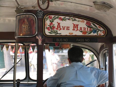 Interior of maltese bus cab with religious simbols