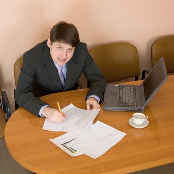 Businessman on a workplace with the laptop and a coffee cup