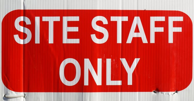 Detail of site staff only sign in white over red
