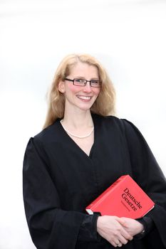 A young lawyer is smiling and holding a law book in hand
