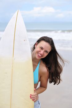 Surf girl holding a board in Brazil
