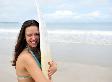 Surf girl holding a board in Brazil
