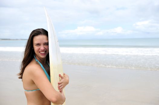 Surf girl holding a board in Brazil
