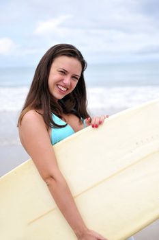 Surf girl holding a board in Brazil
