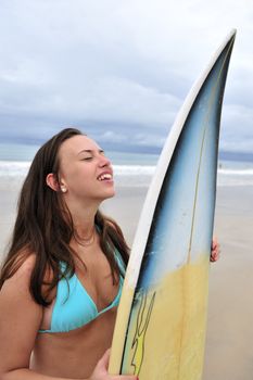 Surf girl holding a board in Brazil
