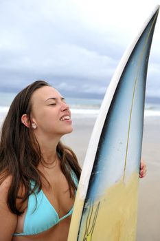 Surf girl holding a board in Brazil
