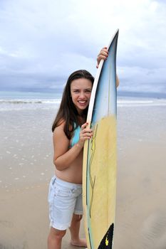 Surf girl holding a board in Brazil
