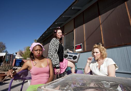 Portrait of three trashy women outdoors