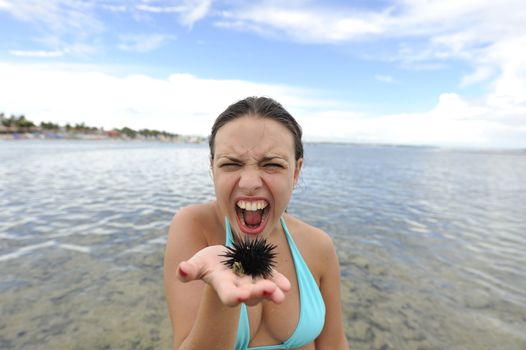 Woman holding an urchin on the beach in Brazil
