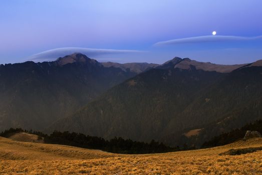 Moon rised and shining over the high mountain.