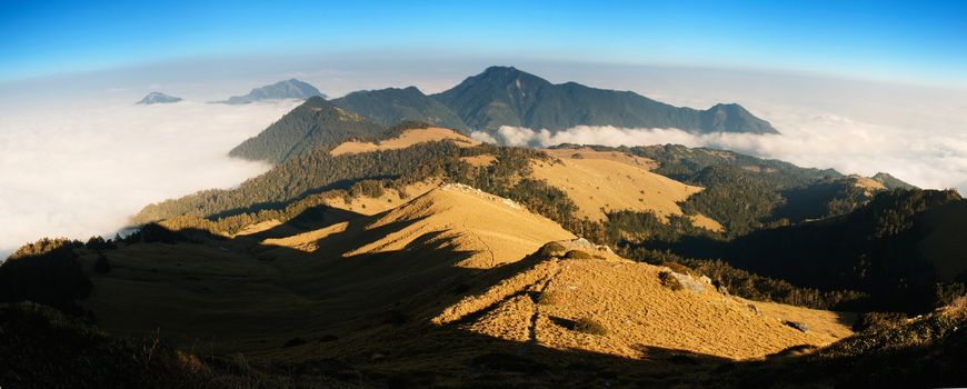 Beautiful panorama mountain landscape with golden grassland .