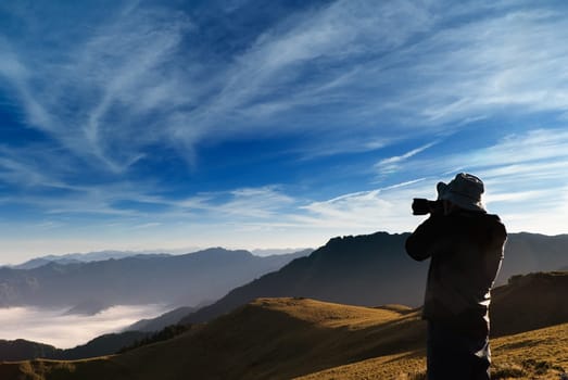 A cameraman standed and shot whith clouds in the outdoor.