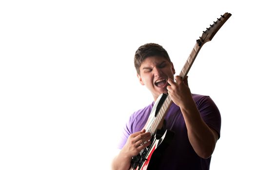 A man in his late teens rocks out while playing his electric guitar.