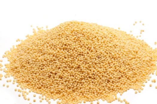 Heap millet is spilt on white background