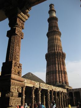 The Qutub Minar, New Delhi, Framed by the pillars and halls of the nearby ruined mosque.