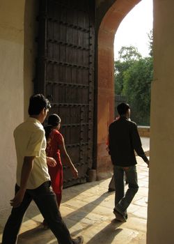 Young Indians walking through an old doorway at Humyan's tomb, New Delhi, India