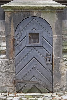 Old church door with a window at level of eyes.