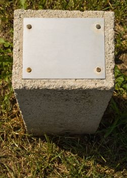 Concrete stone with a metal plate for an inscription 