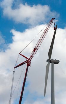 People make repairs wind turbines with the help of a crane