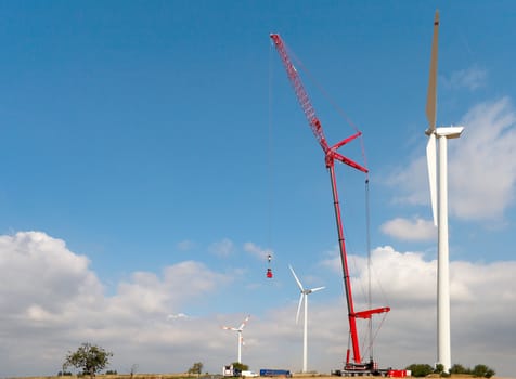 People make repairs wind turbines with the help of a crane