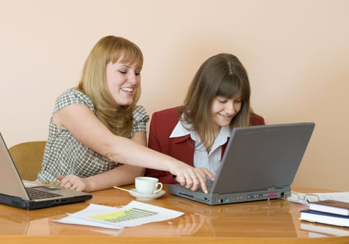 Young girls work sitting at a table