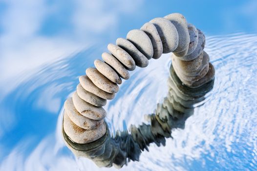 Ripple on the water and the reflection of the stone arch