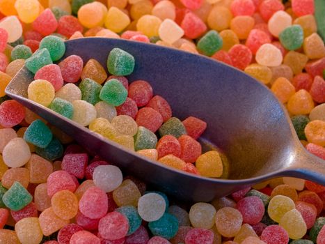 multicolored candies with metallic spoon macro