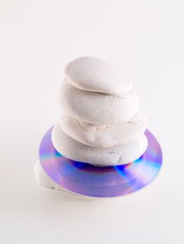 cd disc stuck between beach stones on white