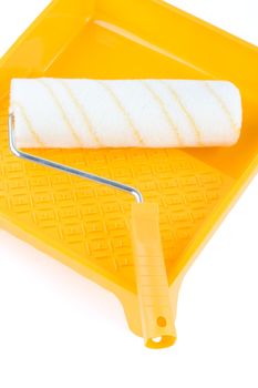Paint roller in yellow paint tray over isolated  white background