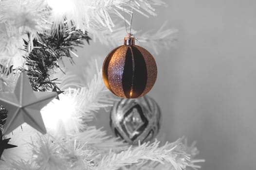 a close up shot of a bauble hanging from a christmas tree.