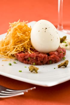 Gourmet dish with egg and raw meat. Studio shot.