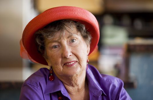 Friendly senior woman wearing a red hat