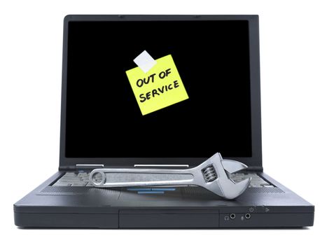 Laptop with an Out of Service sticky note and a spanner over the keyboard. Isolated on white.