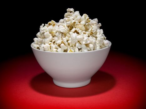 A bowl full of popcorn under the spotlight.