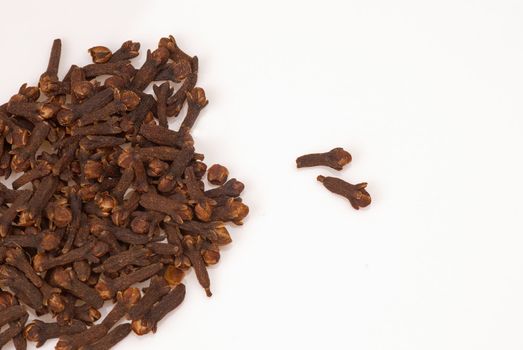 Stack of whole clove buds isolated with copy space