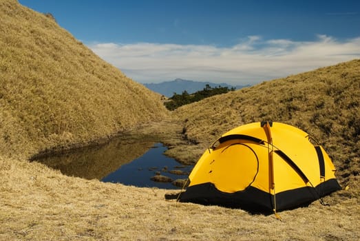 Tent and small lake in high mountain.