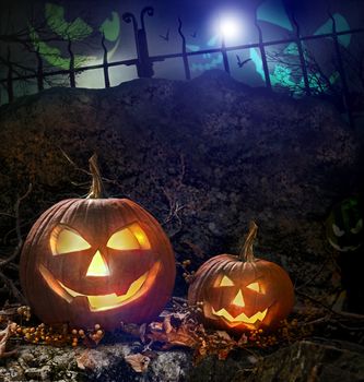 Halloween pumpkins on rocks in a forest at night