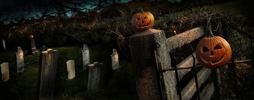 Two Halloween pumpkins sitting on a fence