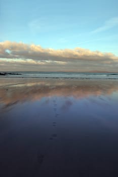 footprints to the waves with reflection crashing in on ballybunion beach ireland