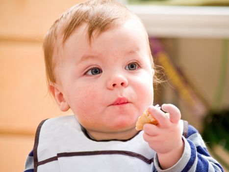 Cute little baby boy  eating bread