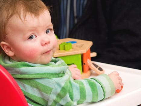 Portrait of a baby boy  looking up from playing