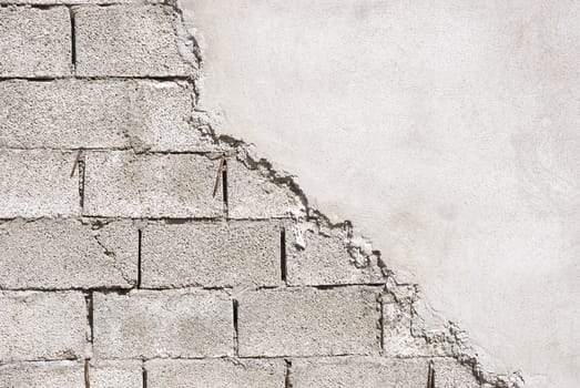 Unfinished wall made of concrete blocks covered with mortar.