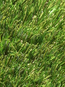 Detail of green grass artificial lawn meadow, useful as a background