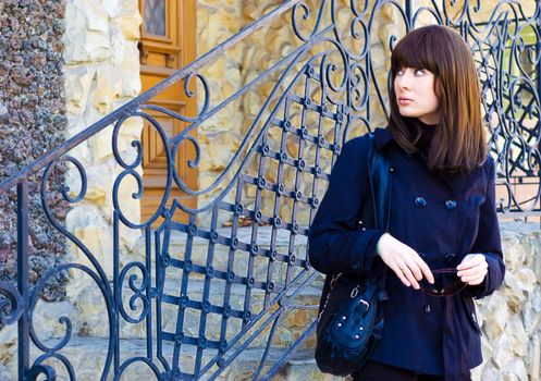 beautiful brunette near grating entrance of building