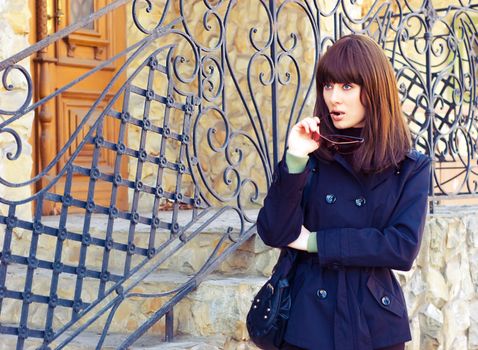 beautiful brunette near grating entrance of building