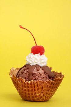chocolate ice cream in wafer cup with whipped cream and cherry