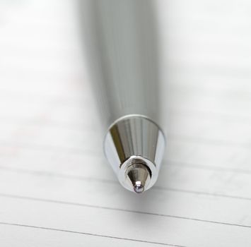 The pen on a notebook. Close up