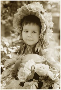 Portrait of little girl in retro style in dress and hat with flowers
